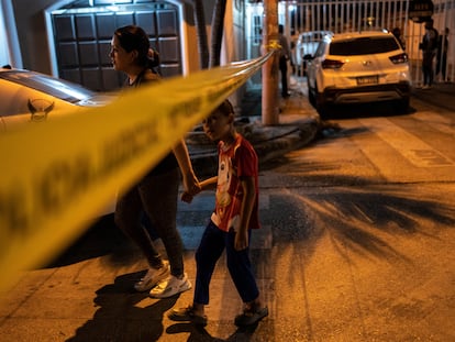 Dos personas pasan delante de la escena de un crimen en Durán, Guayaquil.