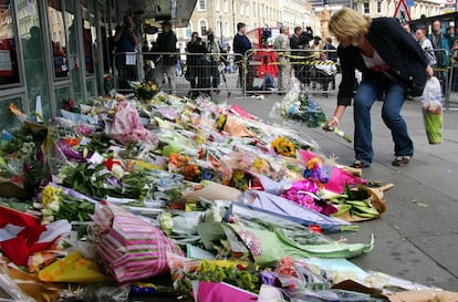 Una mujer deposita un ramo de flores en la estación de metro de King's Cross (Londres), dos días después de los atentados terroristas del 7 de julio de 2005.