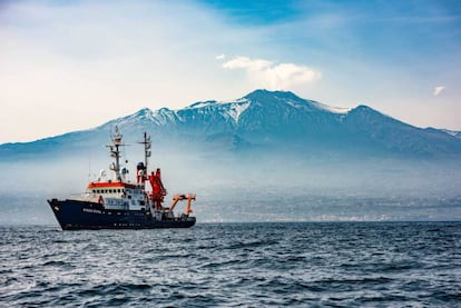 El barco usado para instalar instrumentos submarinos navega frente al Etna.