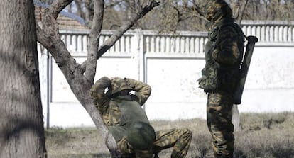 Dos soldados, presuntamente rusos, descansan este lunes cerca de una unidad militar ucrania en Bajchisar&aacute;i.