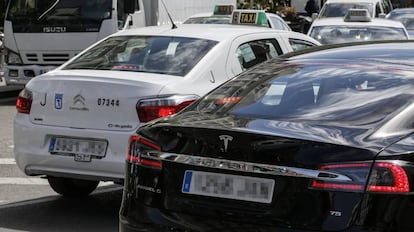 Vehículos con licencias VTC junto a taxis por las calles de Madrid.