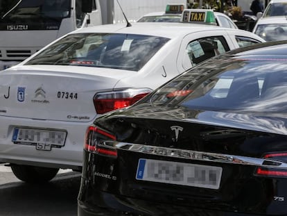 Veh&iacute;culos con licencias VTC junto a taxis por las calles de Madrid.