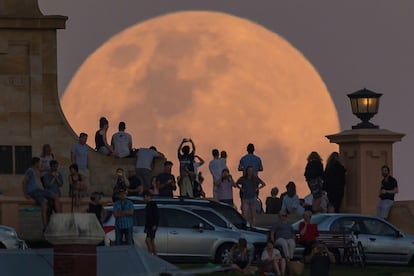 Um grupo de pessoas observa a Superlua em Fremantle, Austrália.