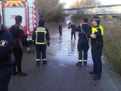 Bomberos y policías de Sevilla revisan la zona donde han quedado atrapados esta mañana dos adultos y dos niños que iban al colegio.