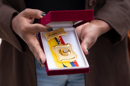 Una mujer que llegó a Furukawa cuando tenía 11 años sostiene una placa entregada durante las disculpas públicas.