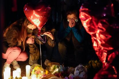 Women pause at a memorial at a vigil honoring the victims of a shooting at the Star Ballroom Dance Studio on Monday, Jan. 23, 2023, in Monterey Park, Calif.