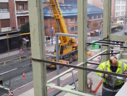 Varios operarios trabajan en la instalación de la nueva escalera de la plaza de abastos de Vitoria. 