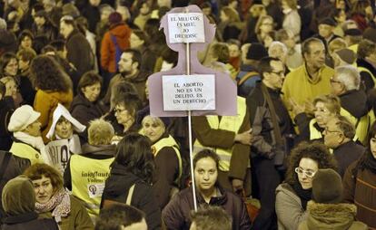 Una manifestante sostiene una pancarta contra la modificaci&oacute;n de la ley del aborto.