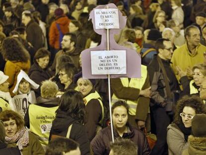 Una manifestante sostiene una pancarta contra la modificación de la ley del aborto.