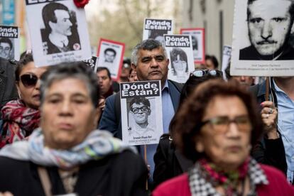 Activistas de la organización chilena de derechos humanos 'Personas detenidas y desaparecidas' muestran imágenes de los desaparecidos durante la dictadura militar (1973-1990) frente al palacio presidencial de La Moneda, en Santiago.