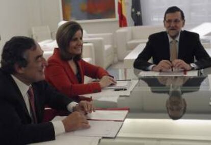 El presidente del Gobierno, Mariano Rajoy (dcha), acompañado de la ministra de la ministra de Empleo, Fátima Báñez, y el presidente de la CEOE, Juan Rosell, durante la reunión con los agentes sociales, celebrada esta mañana en el Palacio de la Moncloa,  para intercambiar puntos de vista sobre la salida de la crisis y ofrecer diálogo.