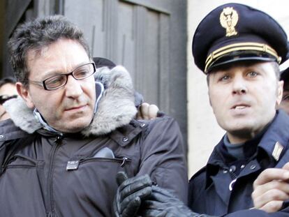 El jefe de la Camorra italiana, Edoardo Contini, es llevado por un agente de la policía italiana a un furgón después de ser detenido en Napolés.