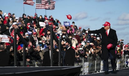 El presidente Donald Trump arroja gorras a sus seguidores durante un mitin en el aeropuerto de Scranton, Pensilvania, el lunes.