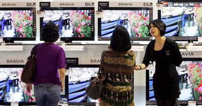 Clientes en una tienda de televisores.