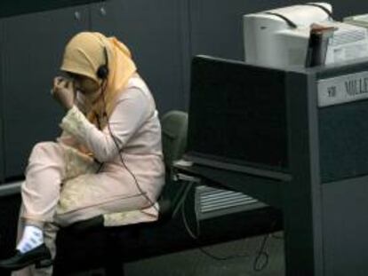 Una agente de bolsa indonesia se toma un descanso durante una jornada en la Bolsa de Yakarta (Indonesia).