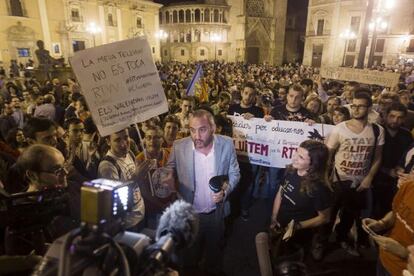 A Canal 9 presenter conducting an interview on Wednesday amid people protesting against the closure of RTVV. 