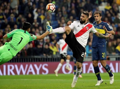 El delantero de River Plate Lucas Pratto (d) intenta rematar ante el portero de Boca Juniors, Esteban Andrada.