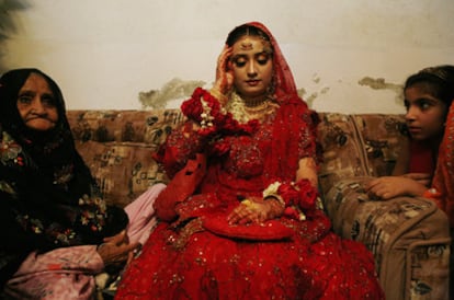 Boda de Aicha (15 años), hija del mulá en la 'madrasa' Jamia Siraj Ul Uloom, Pakistán. La joven novia tiene que aparecer ante los invitados vestida así, llevando joyas de oro, y aguantar con la mirada baja durante horas. Su velo se está moviendo y ella intenta mantanerlo en su lugar, sin moverse. La imagen forma parte de una serie del autor sobre Pakistán.