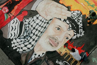 Artistas palestinos trabajan sobre una gran bandera con el retrato de Arafat en la ciudad de Gaza.