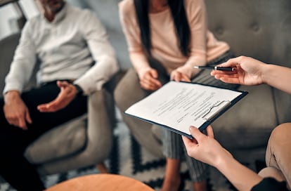 Una pareja estudia los términos del divorcio con una abogada.