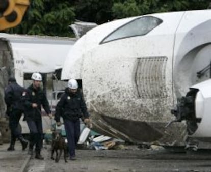 Agentes de la Polic&iacute;a Cient&iacute;fica ayudados de perros prosiguen las investigaciones del tren Alvia accidentado en Santiago de Compostela el pasado 24 de julio cuyos vagones y m&aacute;quinas se encuentran custodiados por la polic&iacute;a en una nave semidescubierta en Padr&oacute;n (A Coru&ntilde;a), a unos veinte kil&oacute;metros de Santiago. 