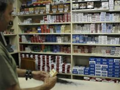 Una persona compra cajetillas de cigarrillos en un estanco de Madrid. EFE/Archivo