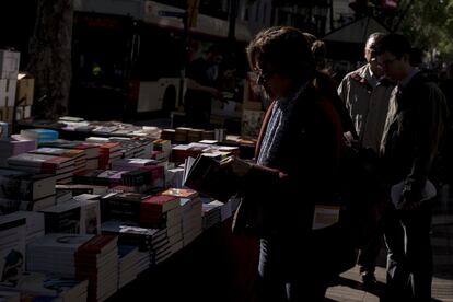 Una lectora hojeando un libro en una parada a Barcelona.