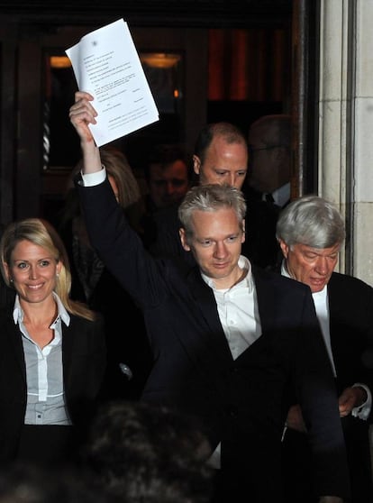 El fundador de WikiLeaks Julian Assange, alza el brazo mientras se dirige a los medios a su salida del Tribunal Superior en el centro de Londres, el 16 de diciembre de 2010. Julian Assange sale en libertad bajo fianza tras el rechazo del tribunal londinese a la apelación de la justicia sueca.