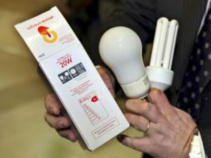 Un hombre muestra unas bombillas de bajo consumo en la oficina central de Correos de Zaragoza. EFE/Archivo