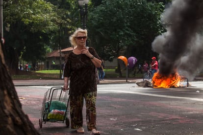 Mulher passa perto de uma barricada feita pelos manifestantes na praça da República.