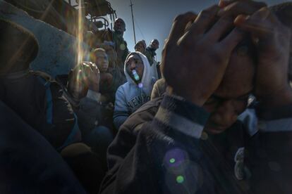 Interceptados por los guardacostas libios a pocas millas de la costa, los refugiados y migrantes esperan en el puerto de Trípoli a ser trasladados a un centro de detención.