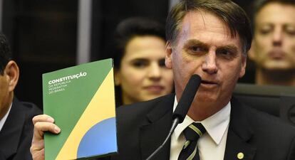 Bolsonaro segura um exemplar da Constituição em novembro de 2018.