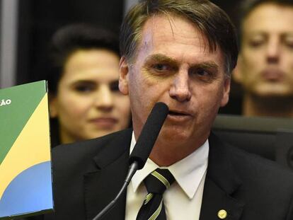 Bolsonaro segura um exemplar da Constituição em novembro de 2018.