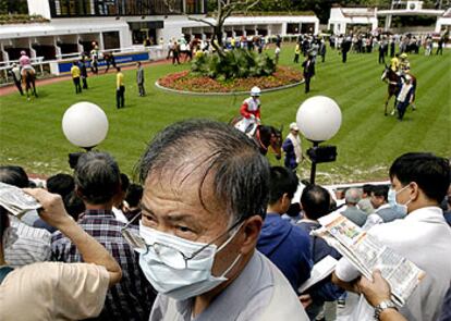 Los asistentes a una carrera de caballos en Hong Kong, con mascarillas para protegerse del misterioso mal.