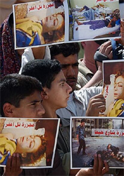 Jóvenes iraquíes muestran fotos de víctimas de la guerra ante la cárcel  de Abu Ghraib.