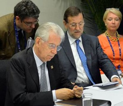 Álvaro Nadal, primero por la izquierda, atiende a Mariano Rajoy, sentado junto al primer ministro italiano, Mario Monti.