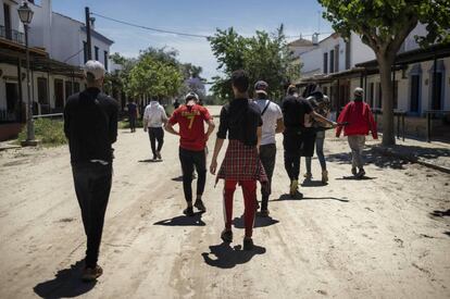 Varios de los jóvenes migrantes se dirigen a la casa que comparten en El Rocío tras apearse del autobús que les traslada desde los cultivos.