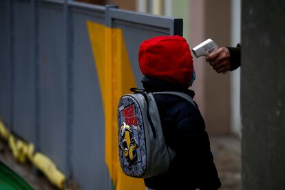 Una profesora toma la temperatura a un alumno de una escuela de Barcelona antes de entrar a clase.