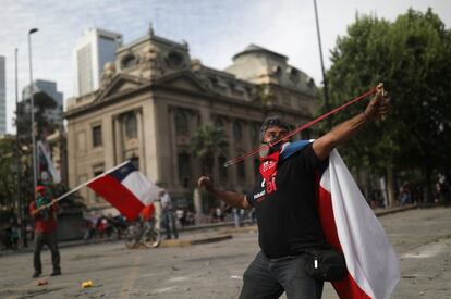 Un manifestante utiliza un tirachinas durante una protesta contra las medidas en económicas del Gobierno en Santiago de Chile.