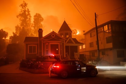 Una familia evacua su vivienda mientras el incendio forestal se acerca a su vivienda en Ventura (California), el 5 de diciembre.