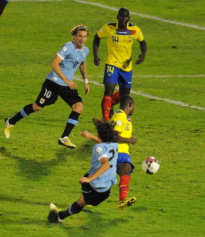 Cavani dispara ante la oposición de un defensa colombiano y la mirada de su compañero Forlán.