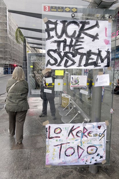 Parada de un autobús en la Puerta del Sol empapelada con las consignas reivindicativas.