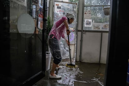 Una comerciante achicaba agua de su tienda afectada por las intensas lluvias en Brooklyn, el viernes. 