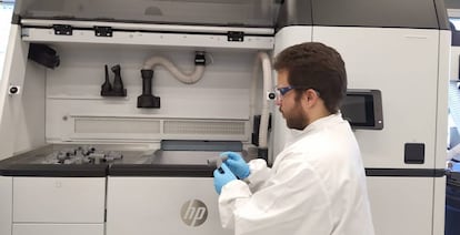 Un ingeniero de HP con piezas fabricadas en 3D para el circuito respiratorio diseñado por el Hospital Príncipe de Asturias.