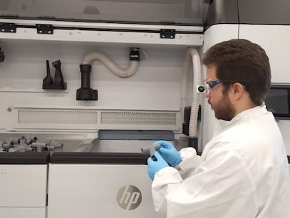 Un ingeniero de HP con piezas fabricadas en 3D para el circuito respiratorio diseñado por el Hospital Príncipe de Asturias.