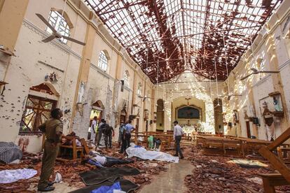 Los cadáveres de varias personas permanecen en el interior de la basílica de San Sebastián en Negombo tras el atentado terrorista, este domingo.