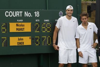 Isner y Mahut posan junto al marcador de Wimbledon en 2010, tras más de once horas en la pista.