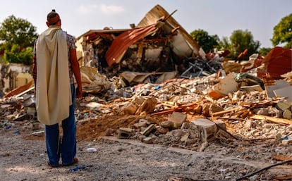 Un hombre reza frente a una vivienda destruida en el kibutz de Be'eri (Sderot), el sábado.