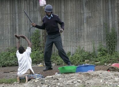 Una mujer suplica a un policía que no la golpee con la porra en la barriada de Mathare.