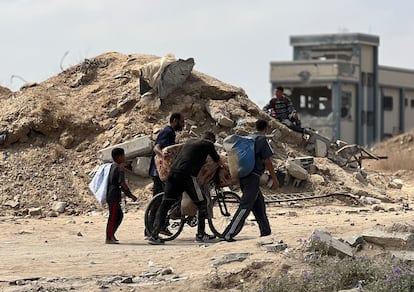 Ciudadanos palestinos desplazados se dirigen a un centro de reparto de ayuda en Deir al Balah, el viernes en Gaza.